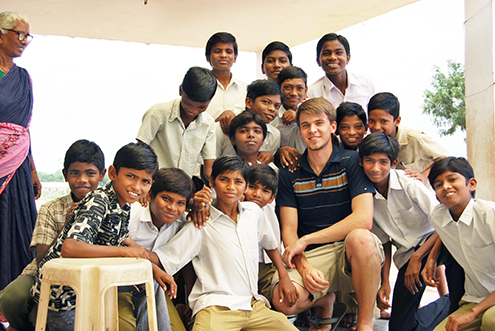 Andrew Luhrs, MD takes a photo with students at the Bharati Integrated Rural Development Society clinic in India