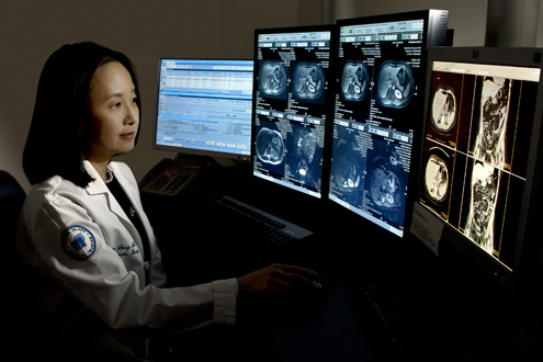 A technician examines medical images