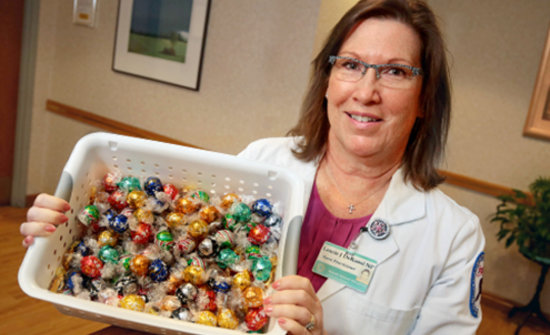 Laurie DeRuosi, NP, with a box of donated Lindt chocolate.