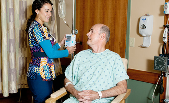 Elderly man being helped by a nurse