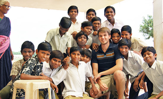 Andrew Luhrs, MD takes a photo with students at the Bharati Integrated Rural Development Society clinic in India