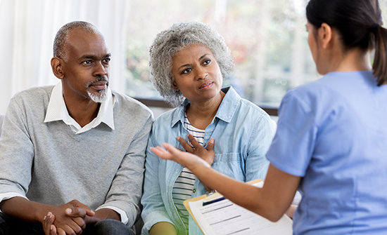 African American couple speaking with a female doctor.