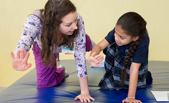 Pediatric physical therapist working with a child.