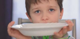 Picky eater at table with plate