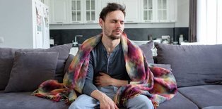 Man on couch with stomach bug