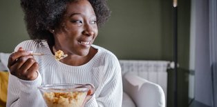 A woman eating cereal and smiling