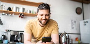 Man looking at phone in kitchen