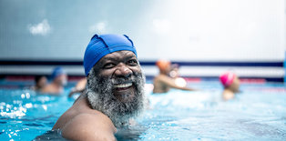 Man swimming in pool smiling