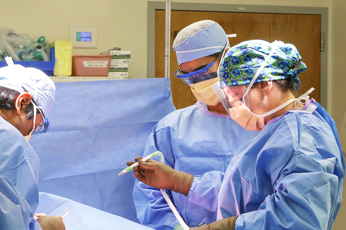 Three members of the Lifespan plastic surgery team performing surgery.